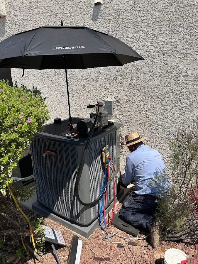 HVAC technician performing outdoor AC maintenance in Kankakee