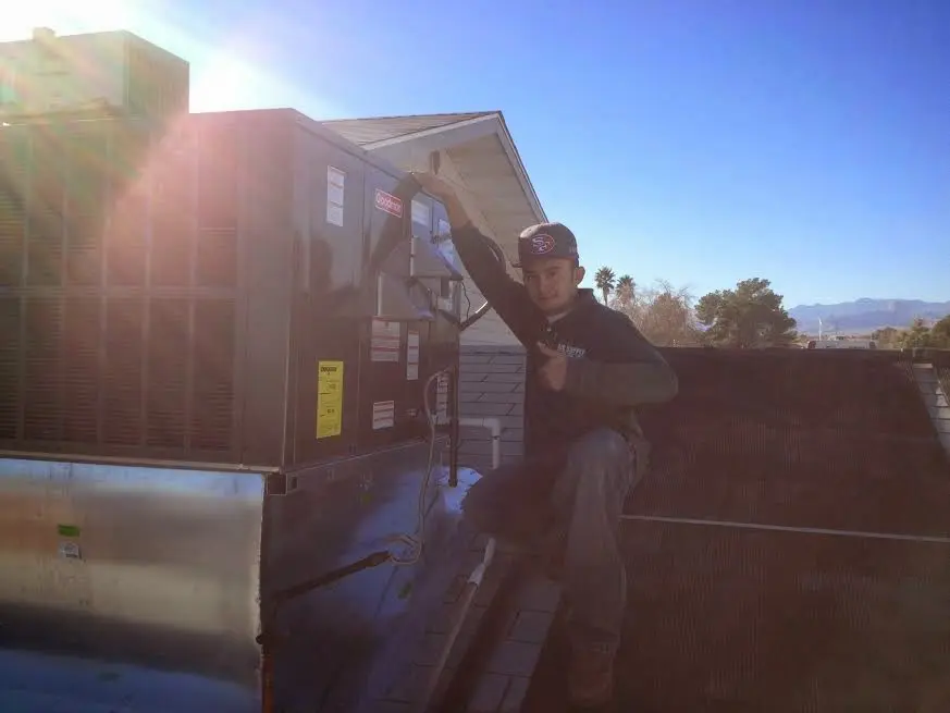 HVAC technician performing HVAC Inspection on a rooftop unit in Kankakee